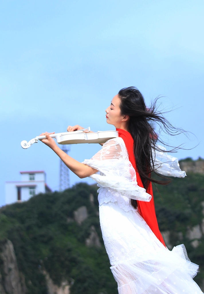 海风中拉小提琴的美女