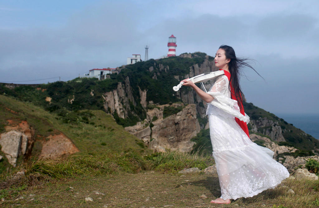 海风中拉小提琴的美女