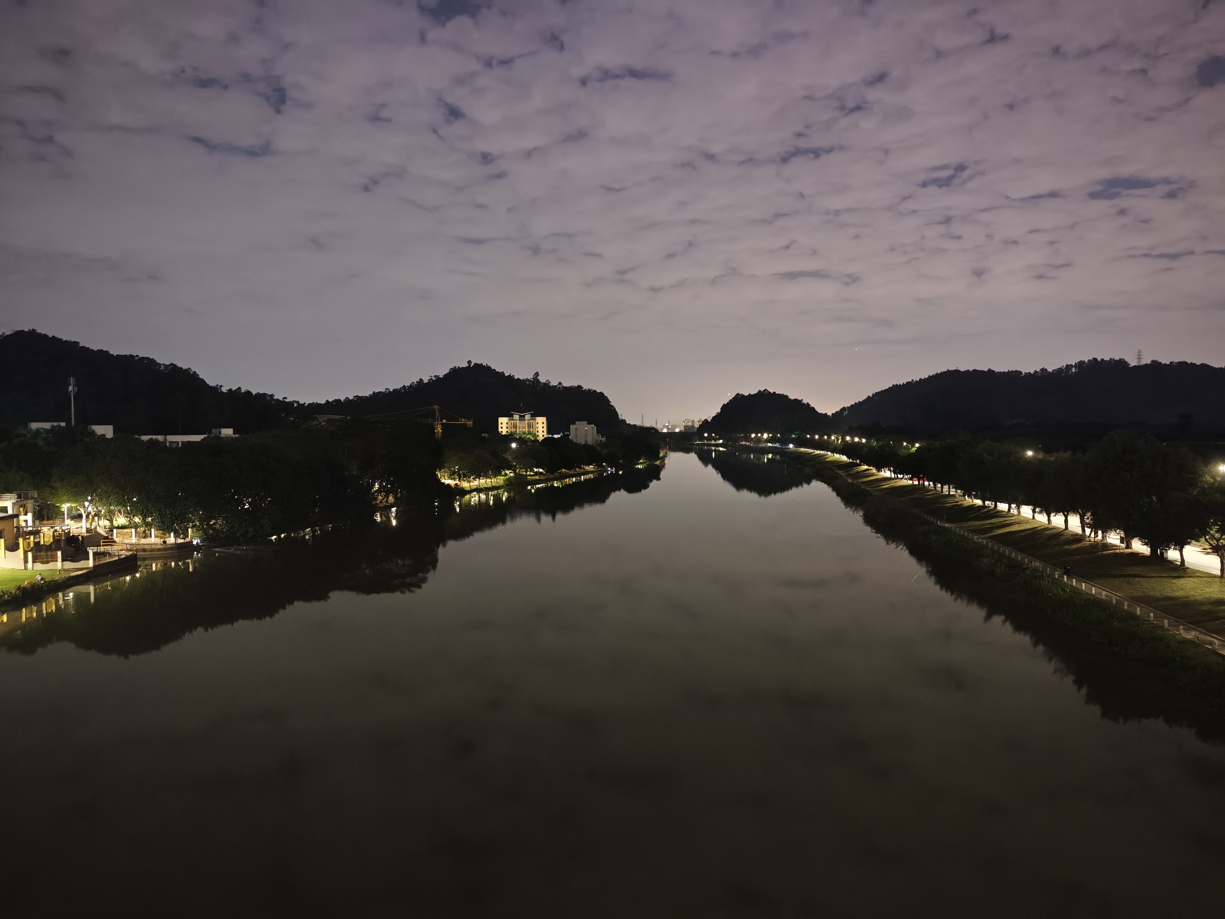 夜幕低垂,华灯初上,我一个人站在一百五十字桥边,赏析着河岸的迷人夜景。灯光璀璨,倒映在河面上,波光粼粼,宛如星河落入凡间。