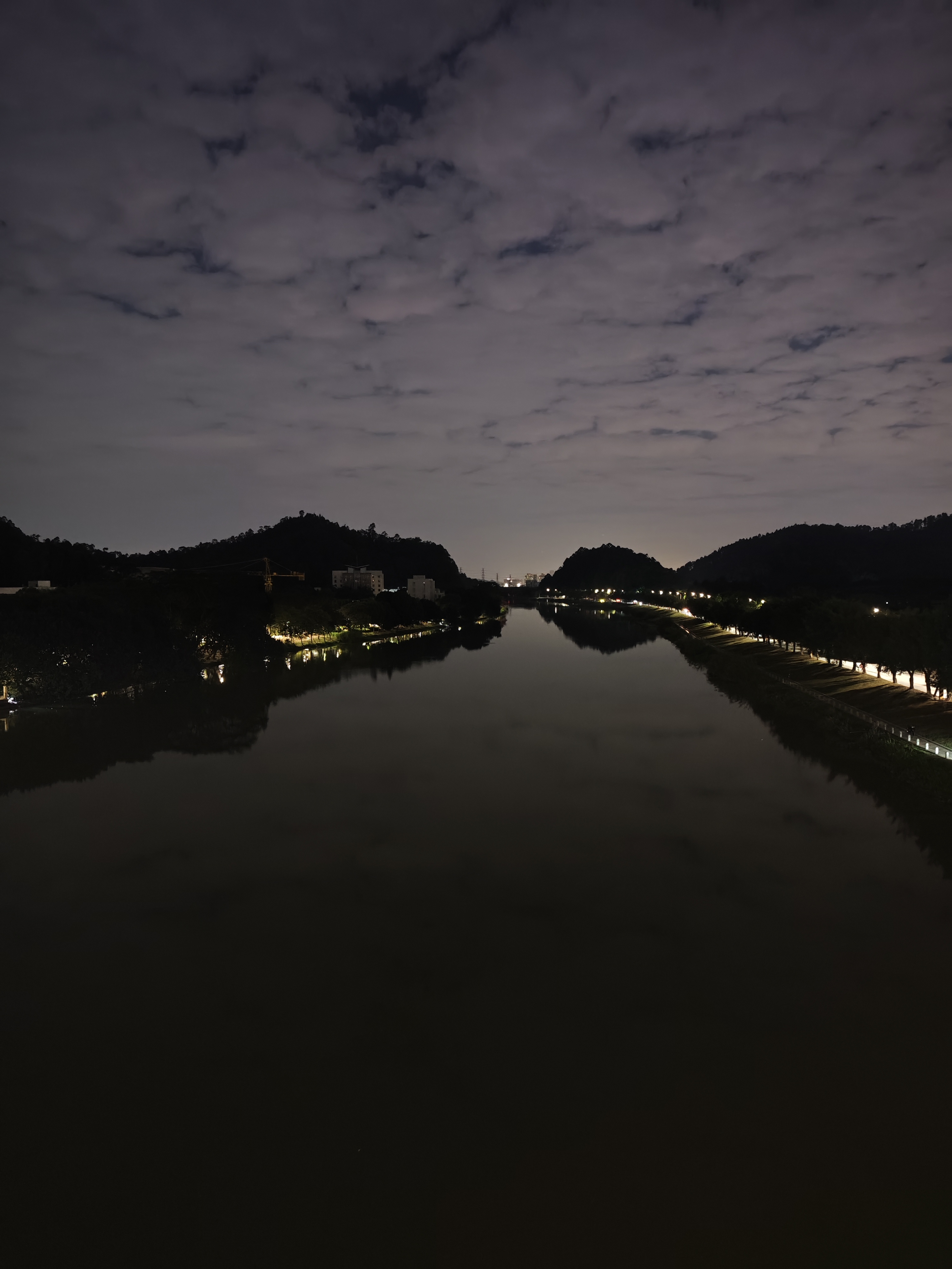夜幕低垂,华灯初上,我一个人站在一百五十字桥边,赏析着河岸的迷人夜景。灯光璀璨,倒映在河面上,波光粼粼,宛如星河落入凡间。