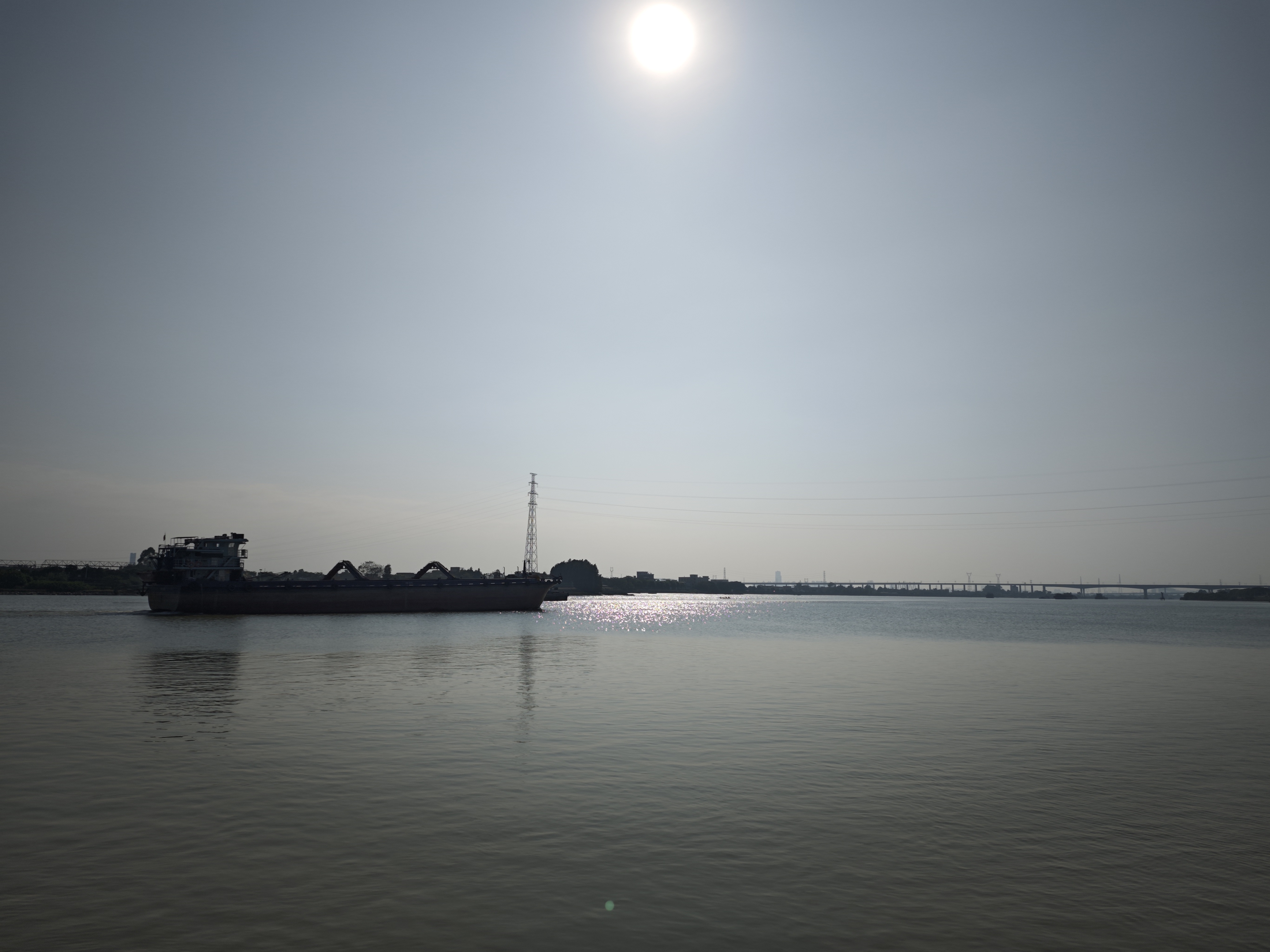 河边游记今日来到河边,见一艘运沙船缓缓驶来。船身庞大,满载黄沙,河水因它而泛起层层波澜。船行渐近,轰鸣声愈发响亮,仿