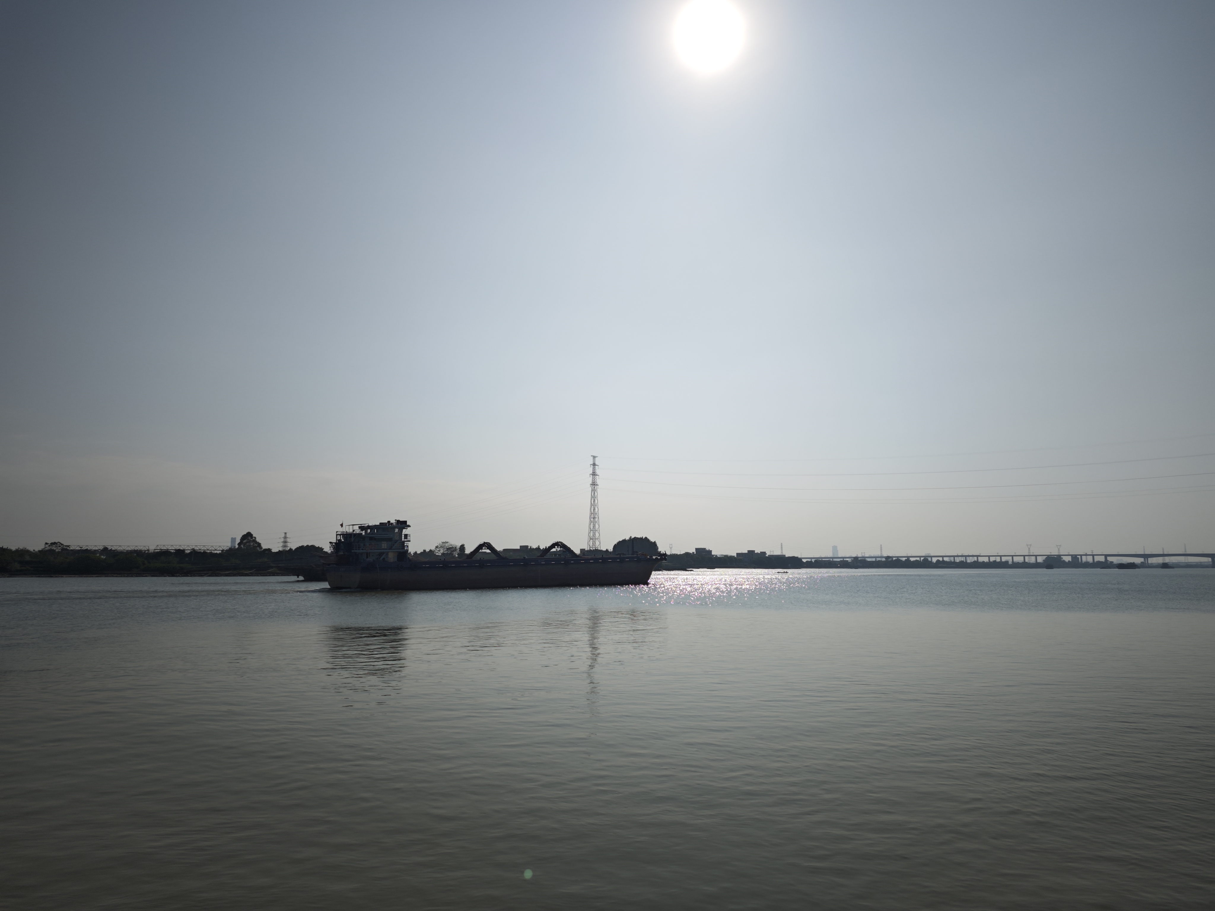河边游记今日来到河边,见一艘运沙船缓缓驶来。船身庞大,满载黄沙,河水因它而泛起层层波澜。船行渐近,轰鸣声愈发响亮,仿