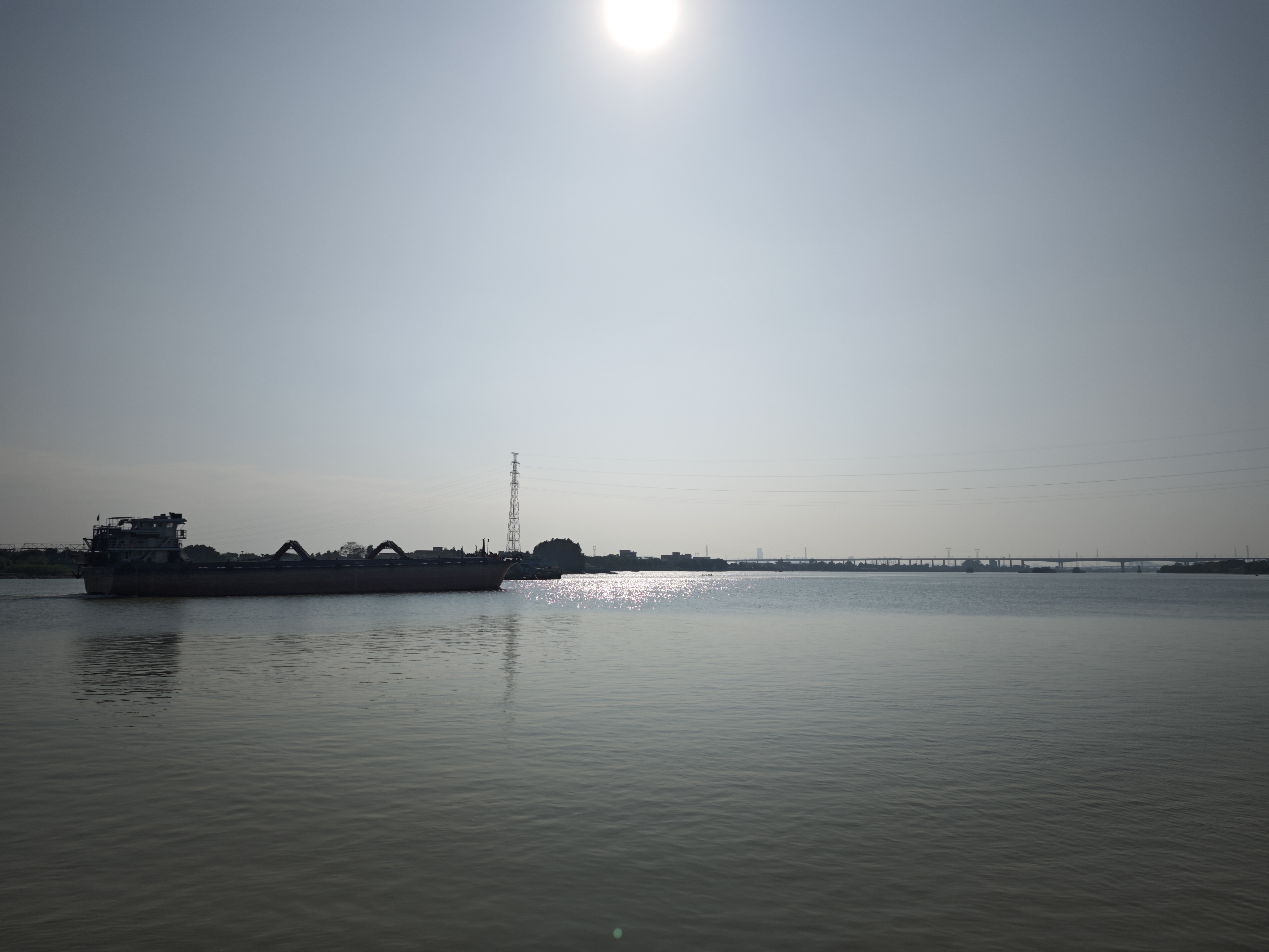 河边游记今日来到河边,见一艘运沙船缓缓驶来。船身庞大,满载黄沙,河水因它而泛起层层波澜。船行渐近,轰鸣声愈发响亮,仿